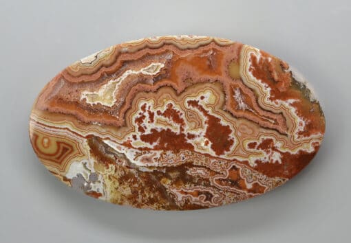 An oval piece of agate on a white surface.