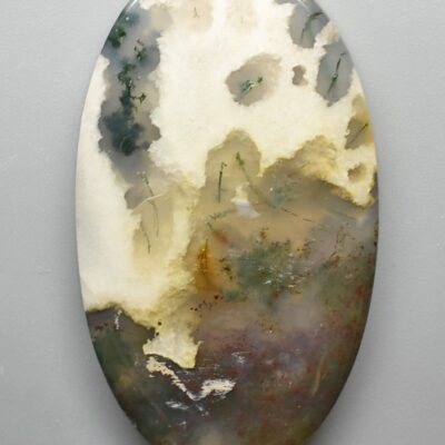 An oval piece of agate on a white surface.