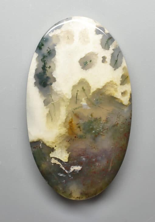 An oval piece of agate on a white surface.