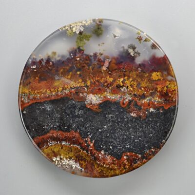A plate with a red, orange, and yellow agate on it.