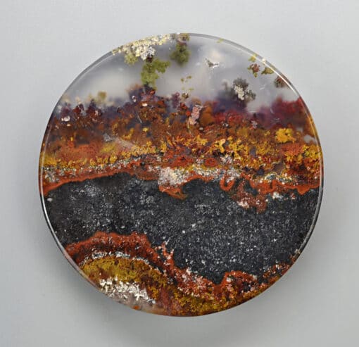 A plate with a red, orange, and yellow agate on it.