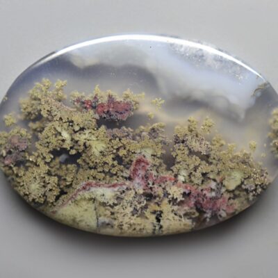 A round piece of agate with moss on it.