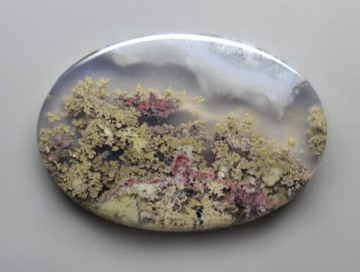 A round piece of agate with moss on it.