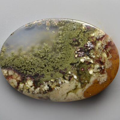 A green and brown agate on a white surface.
