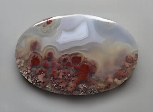 A piece of agate with red and white swirls.