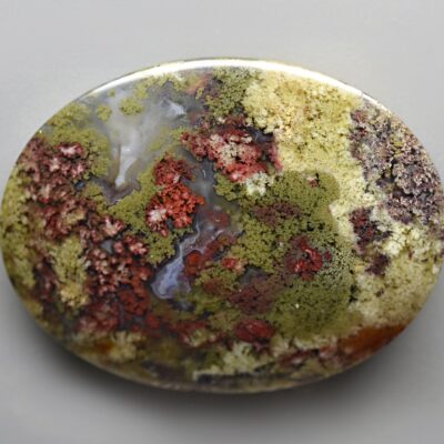 A round piece of mossy stone on a white surface.