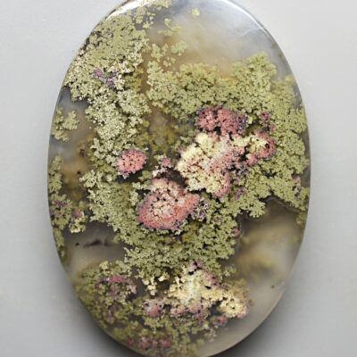 A round piece of agate with moss on it.