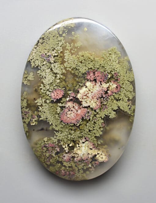 A round piece of agate with moss on it.