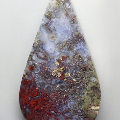 A tear shaped piece of agate on a white surface.
