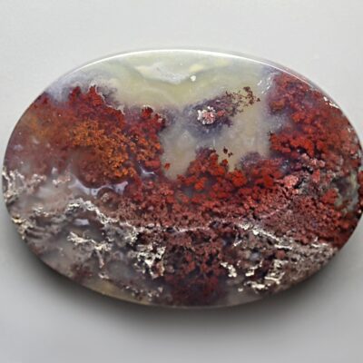A round piece of agate with red and white swirls.