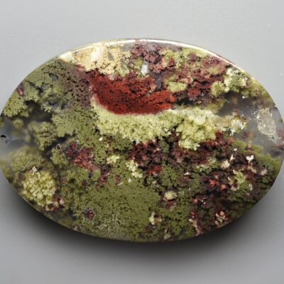 A round piece of agate with moss on it.