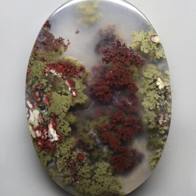 A piece of agate with red and green moss on it.