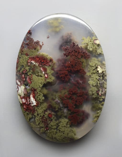 A piece of agate with red and green moss on it.