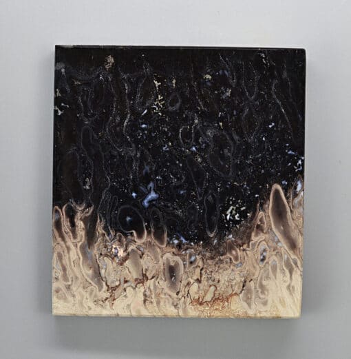 A black and brown painting on a white surface.