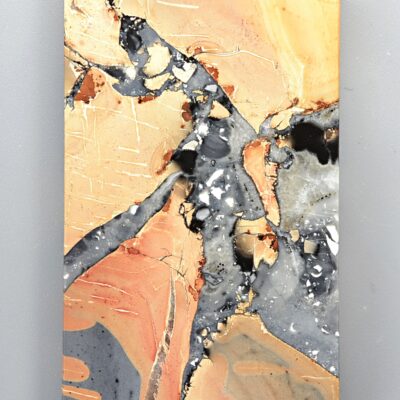 A piece of art with orange and black paint on it.
