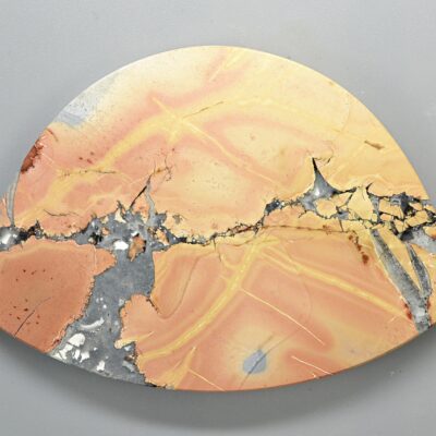 A piece of orange and gray marble on a white surface.