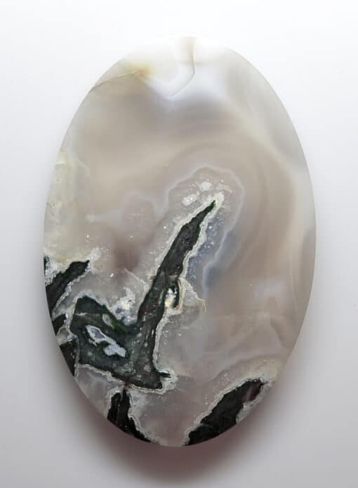 A black and white agate oval on a white surface.