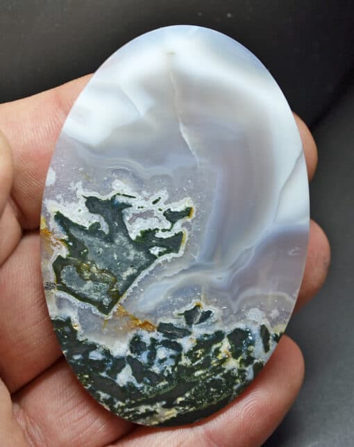 A round piece of agate in a person's hand.