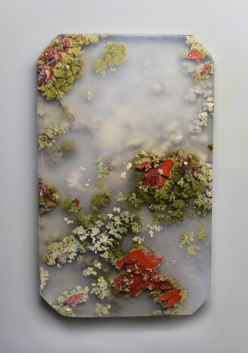 A piece of art with moss and flowers on it.