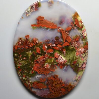 A piece of red and green agate on a white surface.