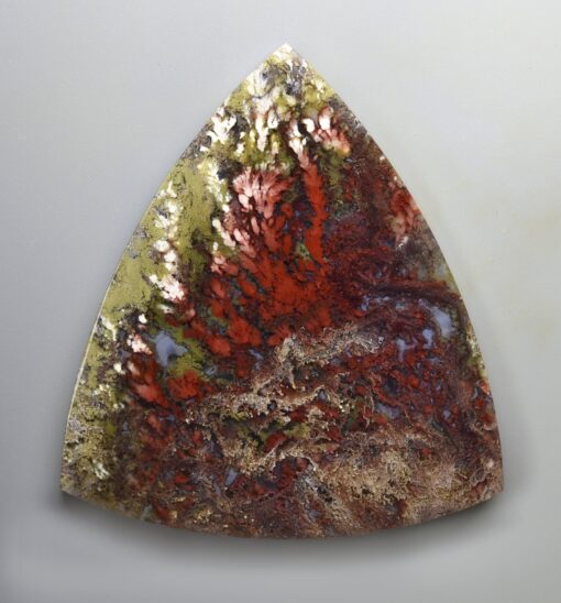 A triangular piece of stone with red and green paint.