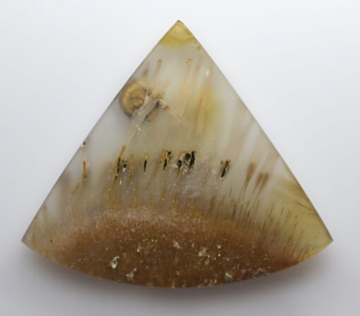 A triangular piece of agate on a white surface.