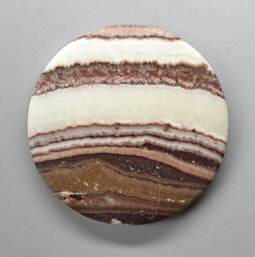 A round piece of agate with brown and white stripes.