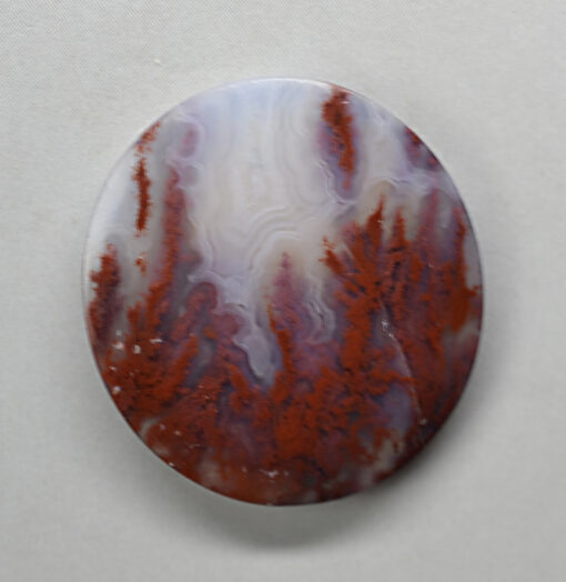 A circular piece of agate with red and white swirls.