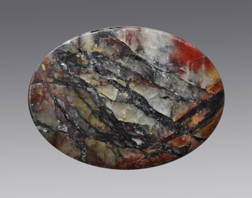 A circular piece of marble with a black and red pattern.