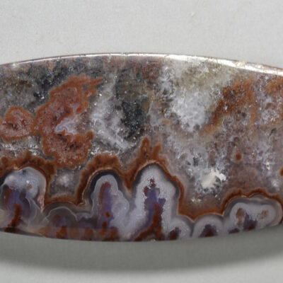 An oval piece of agate on a white surface.