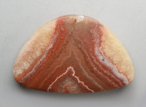 A triangular piece of agate on a white surface.