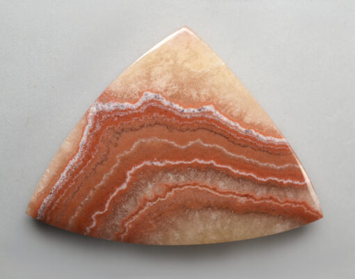 A triangular piece of agate on a white surface.