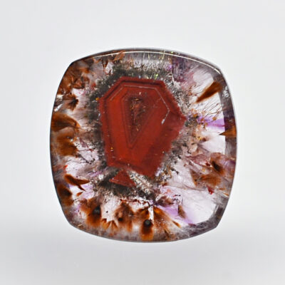 A red and brown stone with a flower on it.