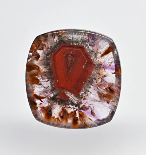 A red and brown stone with a flower on it.