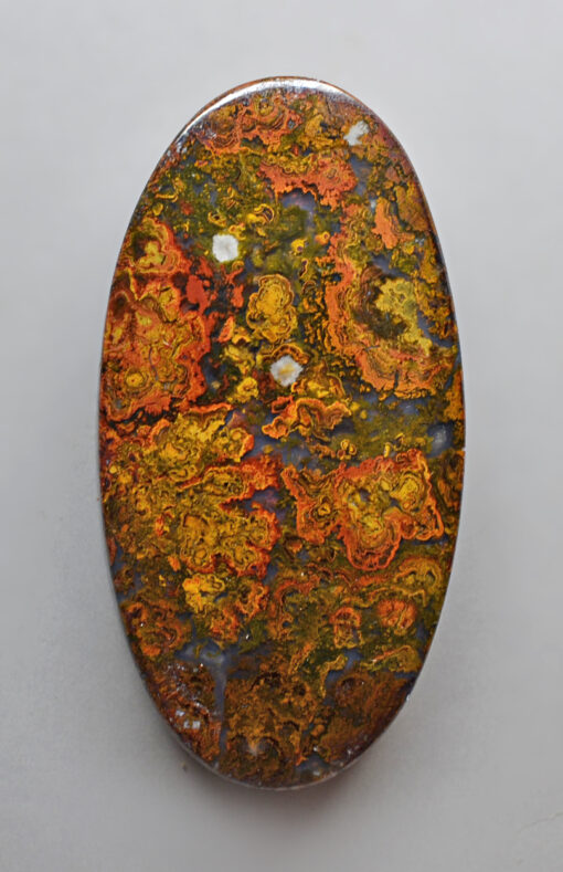 An oval shaped piece of yellow and orange colored jasper.