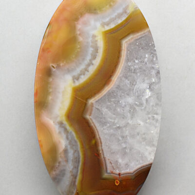 An oval agate pendant on a white surface.