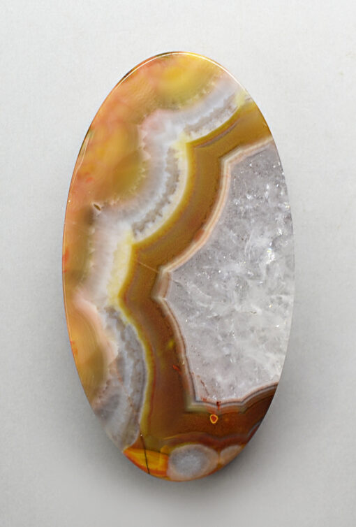 An oval agate pendant on a white surface.