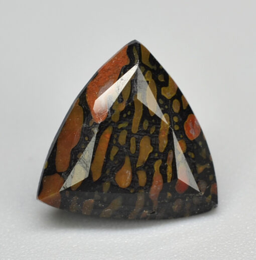 A triangular shaped stone with a red, orange and black pattern.
