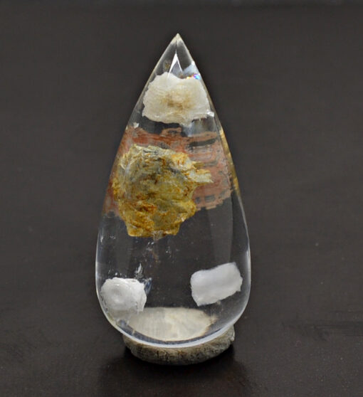 A tear shaped piece of quartz on a table.