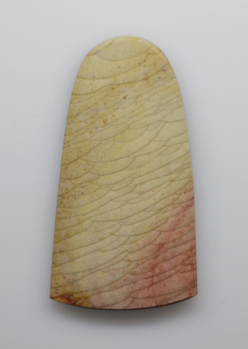 A piece of stone with a pink and yellow color.