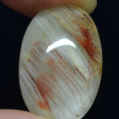 A person holding a piece of white quartz with red streaks.