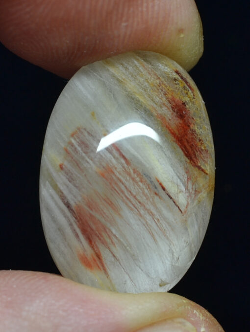 A person holding a piece of white quartz with red streaks.
