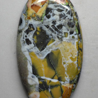 A piece of yellow and black marble on a white surface.