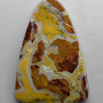 A triangle shaped piece of yellow and white agate.