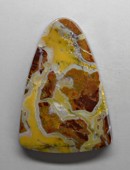 A triangle shaped piece of yellow and white agate.