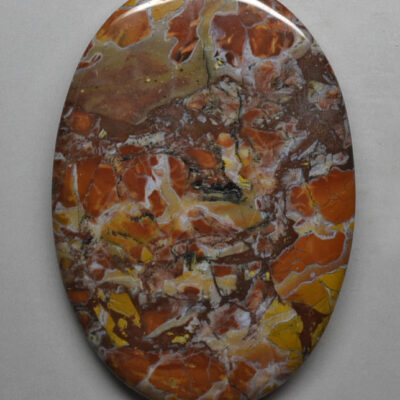 A piece of orange and brown marble on a white surface.