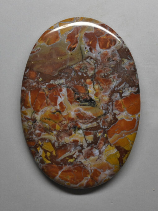 A piece of orange and brown marble on a white surface.