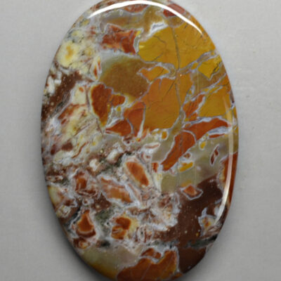 A round piece of jasper with orange and brown swirls.