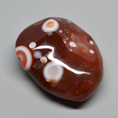 A brown and white agate stone with white dots.