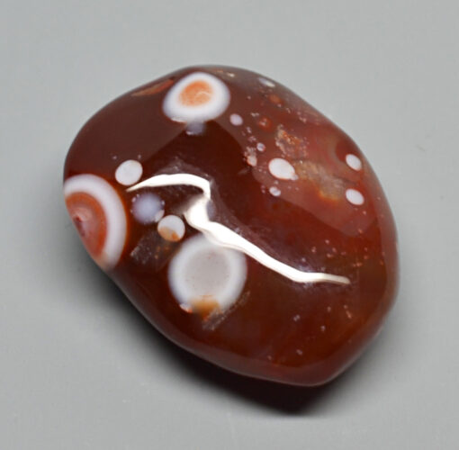 A brown and white agate stone with white dots.